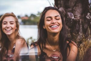 Two ladies laughing show the power of a smile