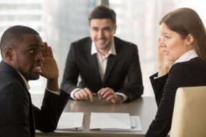 three people sitting around a table at a job interview